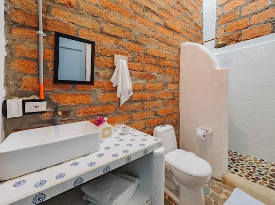 Bano con paredes de ladrillo y azulejos azules