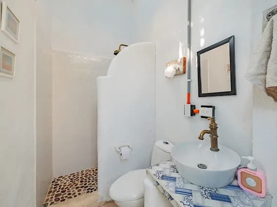 Bano blanco con ducha abierta