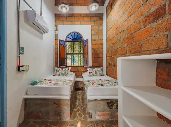 Habitacion doble con paredes de ladrillo y AC