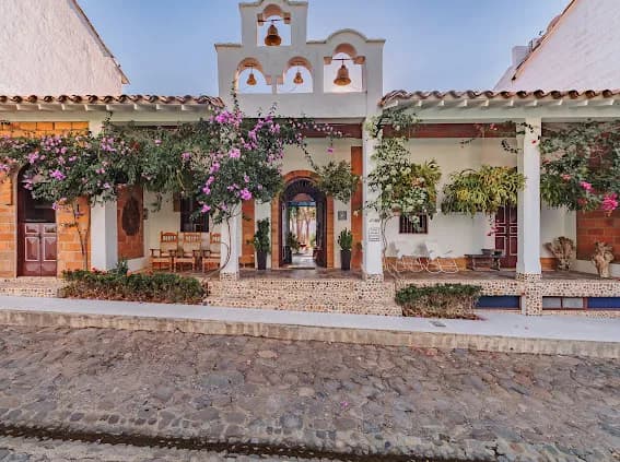 Fachada con campanario y buganvilias