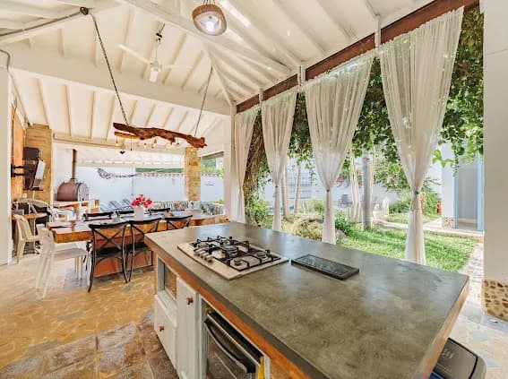 Cocina con cortinas y vista al jardin