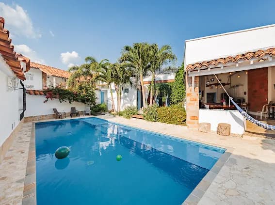 Piscina con palmeras y patio cubierto