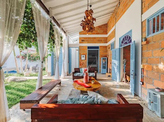Terraza cubierta con sofas de madera y vista al jardin